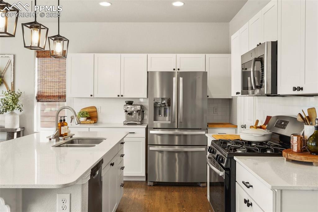 Image 10 of 36: Kitchen featuring decorative backsplash, stainless steel appliances, and qu