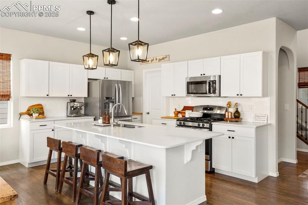 Image 4 of 36: Kitchen featuring decorative backsplash, stainless steel appliances, and qu