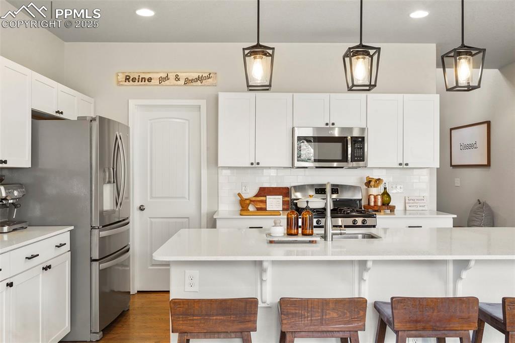 Image 9 of 36: Kitchen featuring decorative backsplash, stainless steel appliances, and qu