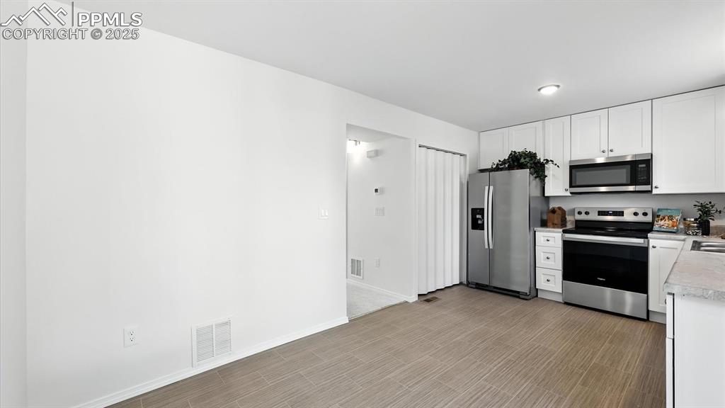 Image 13 of 50: Updated Kitchen with LVP floors and all new stainless steel appliances.