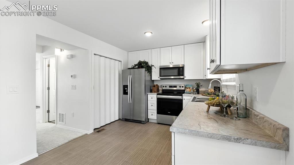 Image 14 of 50: The Kitchen includes a pantry closet and ample white shaker cabinets and co