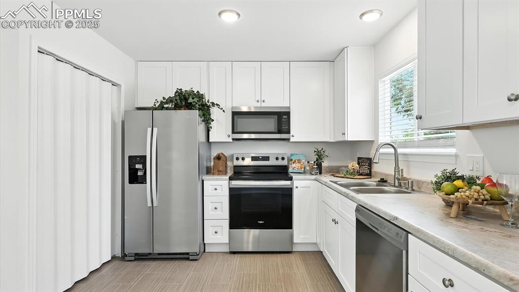 Image 15 of 50: Appliances include a side by side refrigerator, smooth top range oven, buil