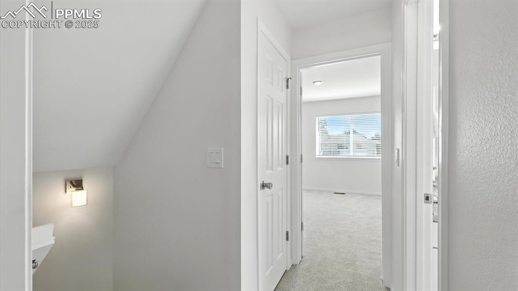 Image 22 of 50: Stairs to the upper level and view into the Primary Bedroom and renovated F