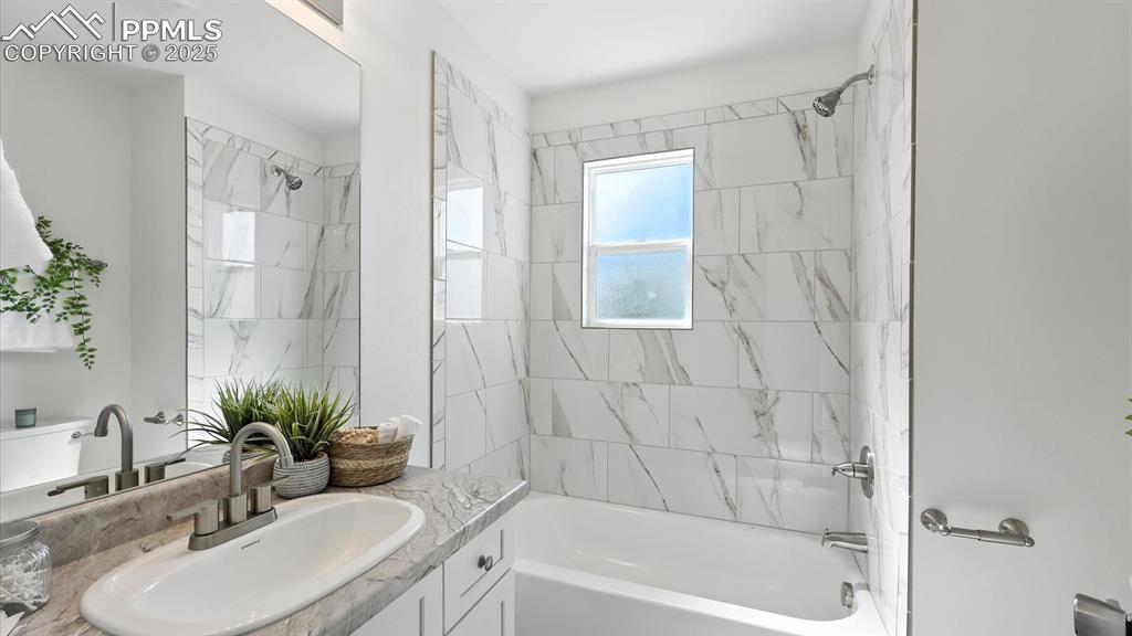 Image 23 of 50: The Full Bathroom offers a vanity, mirror, and tiled tub/shower.