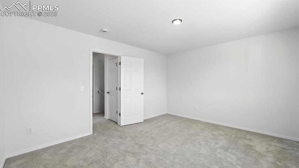 Image 24 of 50: Spacious Primary Bedroom with new carpet and easy access to the upper level