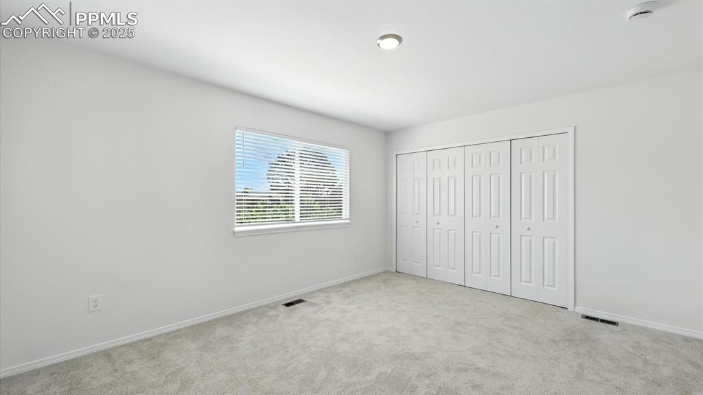 Image 26 of 50: Large window in the Primary Bedroom with beautiful views and lots of natura