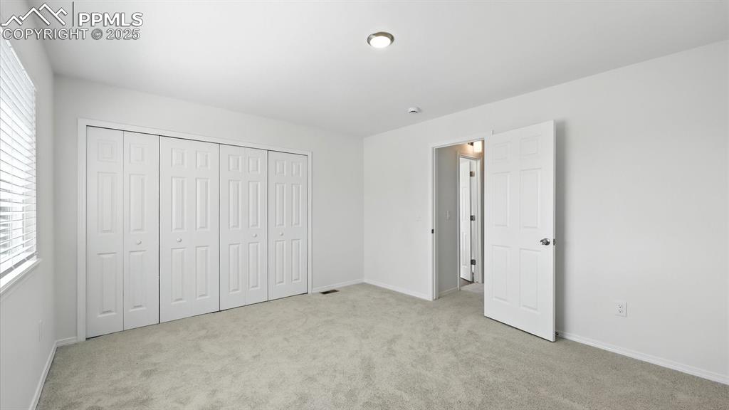 Image 28 of 50: Upper Level Primary Bedroom with view of the entrance to the Full Bathroom 