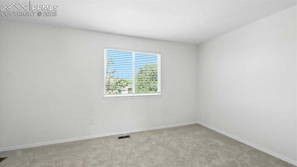 Image 29 of 50: Upper Level vaulted Bedroom #2 with neutral carpet.