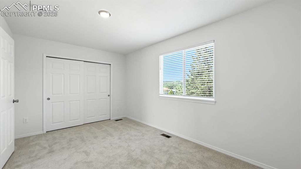 Image 31 of 50: Upper Level Bedroom #2 with beautiful views from large bedroom window.