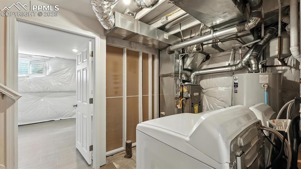 Image 36 of 50: Basement Laundry/Utility Room with view into one of two partially finished 