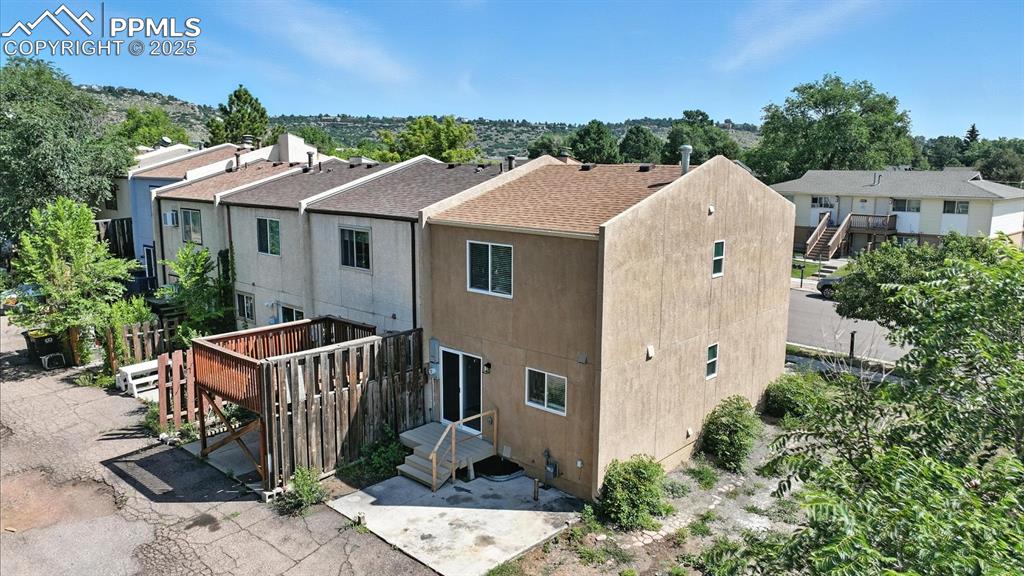 Image 44 of 50: Rear view of end unit townhome with private concrete pad for parking and si