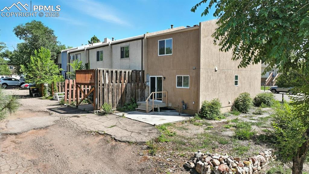 Image 46 of 50: Rear view and side view of home, lot, and private concrete pad for parking.