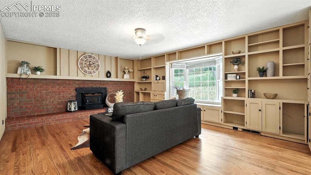Image 20 of 50: The step-down family room exudes warmth with hardwood floors, wood-paneled