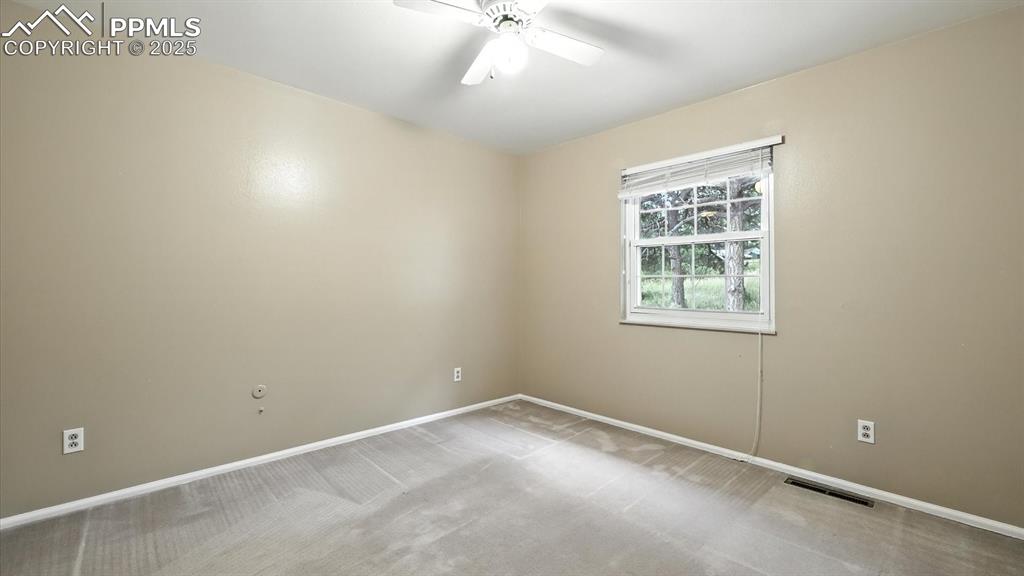 Image 24 of 50: Upper Level Bedroom #1 with lighted ceiling fan and neutral carpet.