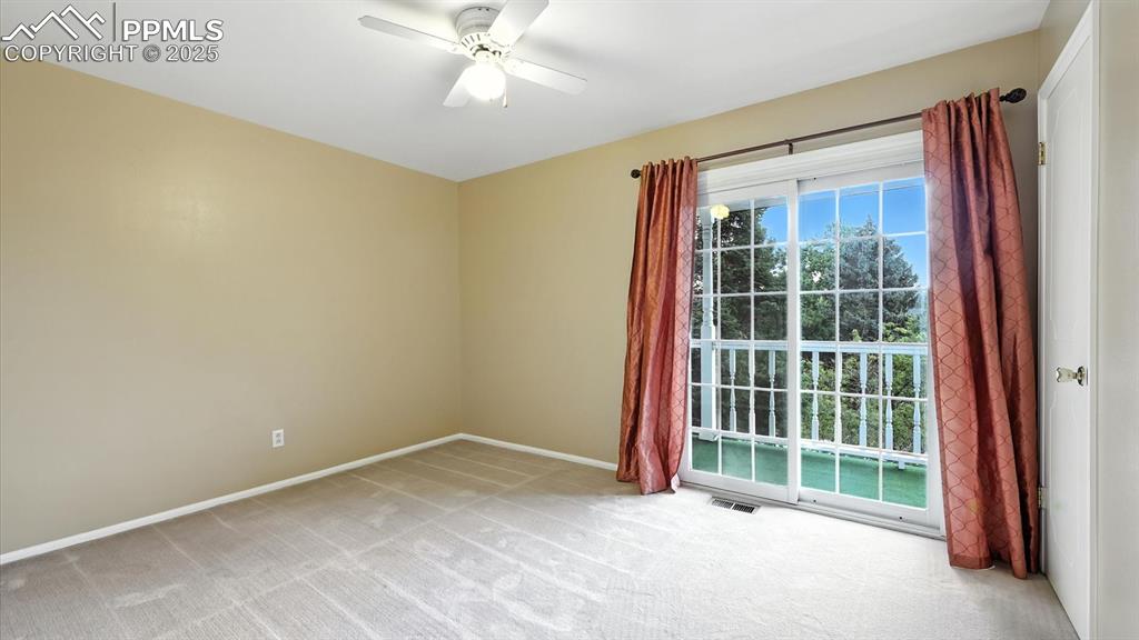 Image 26 of 50: Upper Level Bedroom #2 with neutral carpet, lighted ceiling fan, and slider