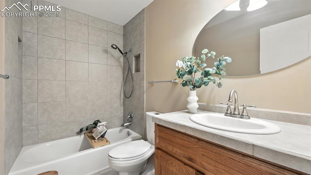 Image 29 of 50: Upper Level Full Bathroom with vanity, mirror, and tiled tub/shower.