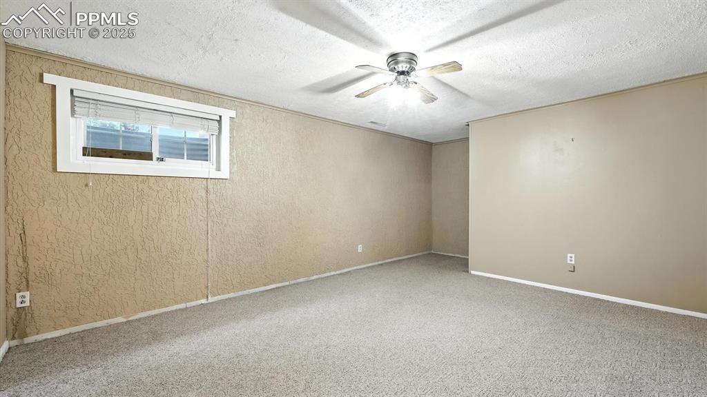 Image 36 of 50: Basement Family Room with neutral carpet and lighted ceiling fan.