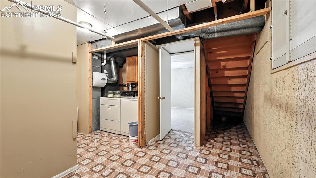 Image 38 of 50: Basement Laundry Room with vinyl floor and washer and dryer.
