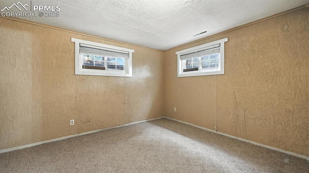 Image 40 of 50: Basement Bedroom #4 with neutral carpet.