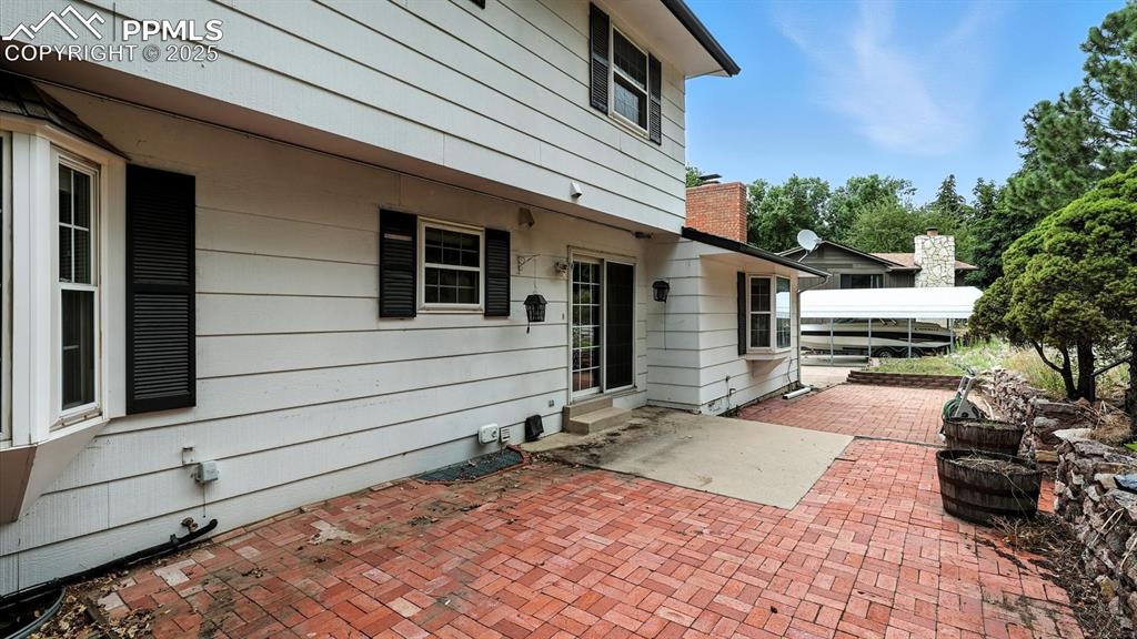 Image 45 of 50: Backyard concrete and brick patio for outdoor dining and relaxation.