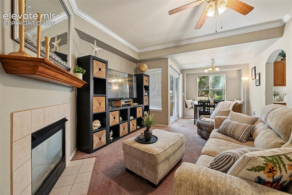 Image 11 of 36: Living area featuring a fireplace with a tile surround and wood mantle, a c