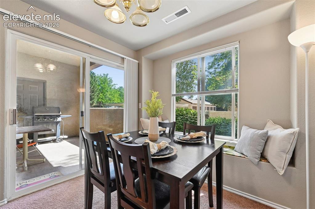 Image 15 of 36: Dining area with sliding glass door access to an outdoor patio