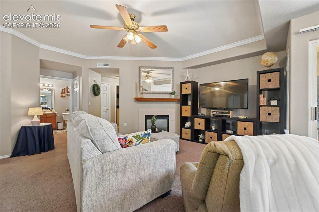 Image 22 of 36: Living area featuring a fireplace with a tile surround and wood mantel, cro