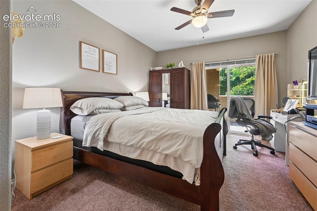 Image 24 of 36: Bedroom featuring textured carpeting, a ceiling fan with light fixture, and