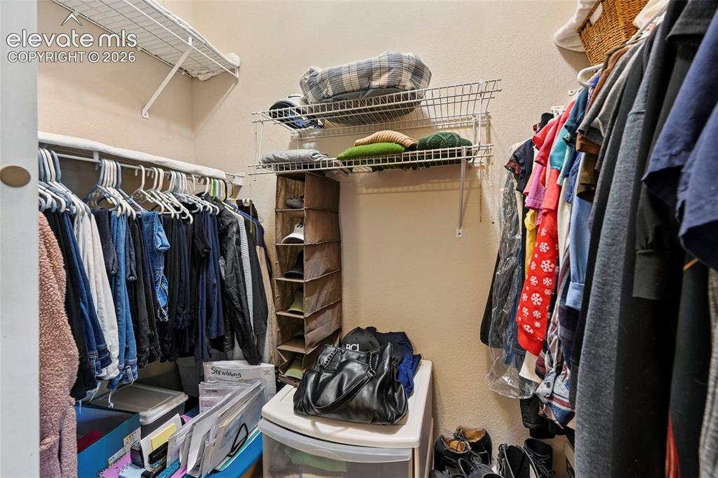 Image 28 of 36: Walk-in closet featuring built-in wire shelving and hanging rods