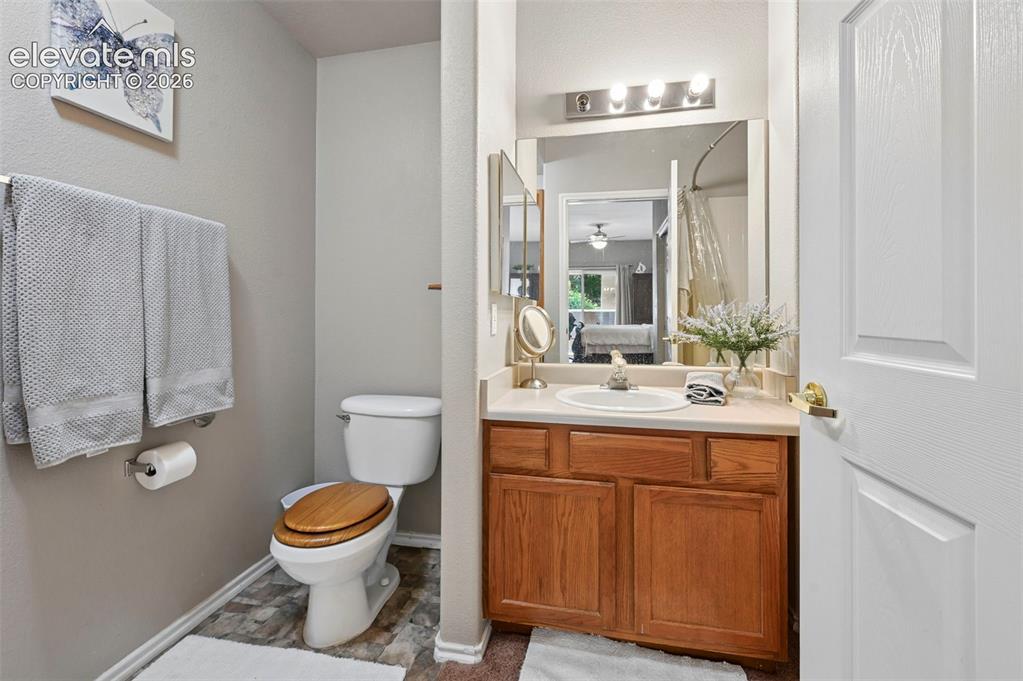 Image 29 of 36: Bathroom featuring a single vanity with wood cabinetry, a white countertop,