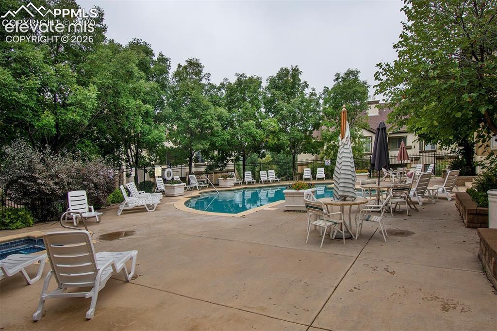 Image 3 of 36: Outdoor pool area featuring a curved swimming pool, expansive concrete deck