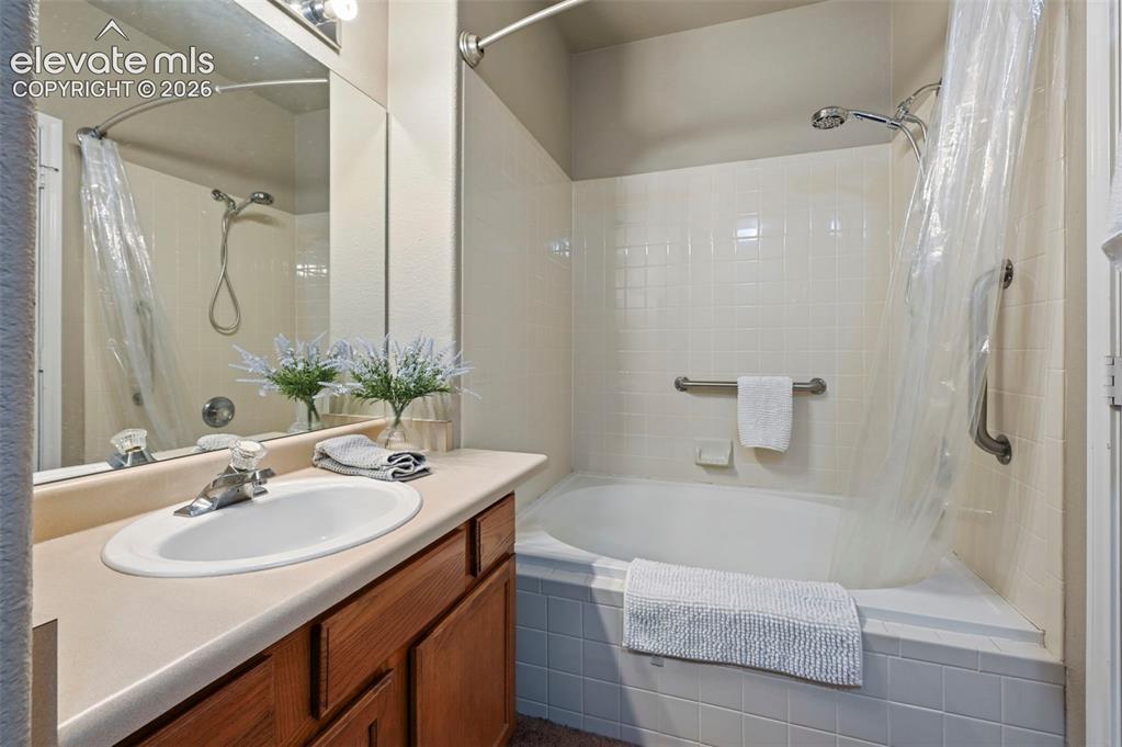 Image 30 of 36: Bathroom featuring a vanity with an integrated sink, a large mirror, and a