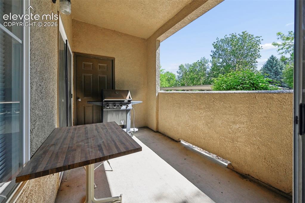 Image 31 of 36: Private exterior balcony featuring a stucco finish, concrete flooring, and