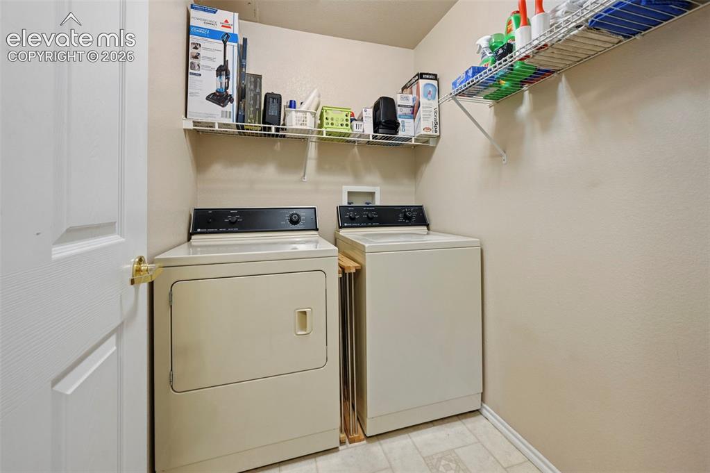 Image 32 of 36: Dedicated laundry area featuring a white paneled door with brass hardware,