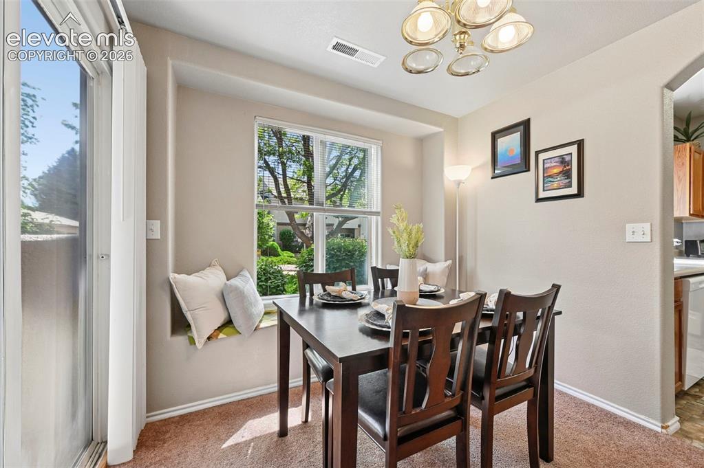 Image 36 of 36: Dining area featuring a built-in window seat, a framed window, and carpet f