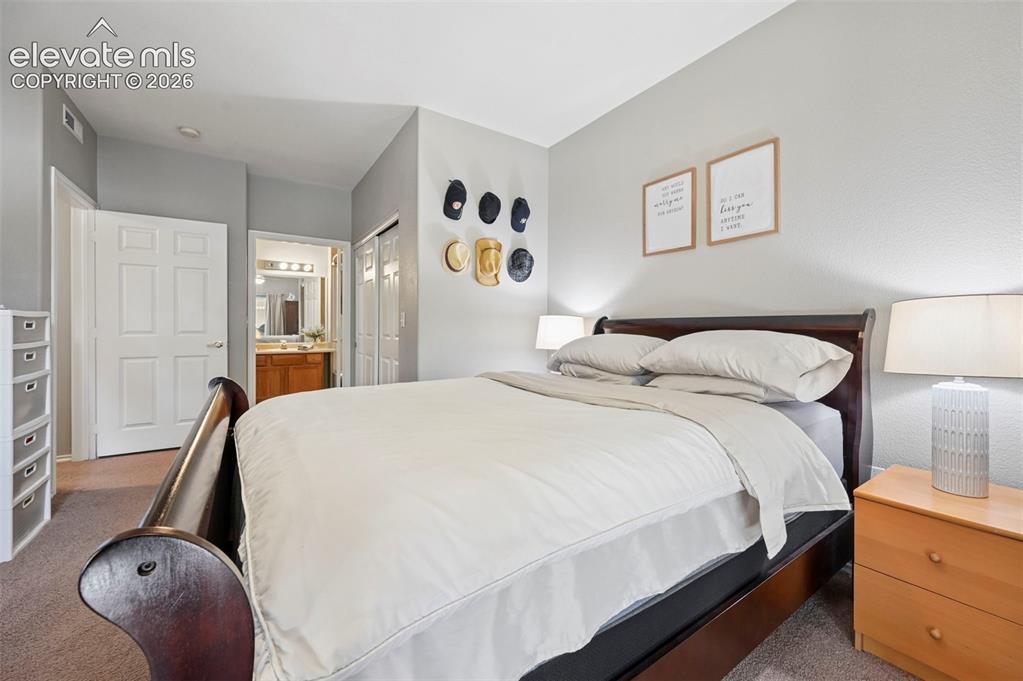 Image 9 of 36: Carpeted bedroom featuring light gray walls, white six-panel doors, and a p