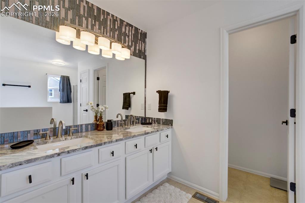 Image 26 of 46: Slab granite counters with custom backsplash.