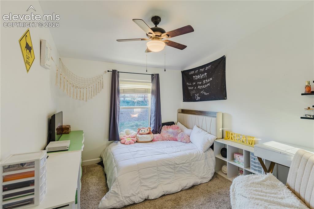 Image 16 of 30: Carpeted room featuring a ceiling fan with integrated lighting, a window wi