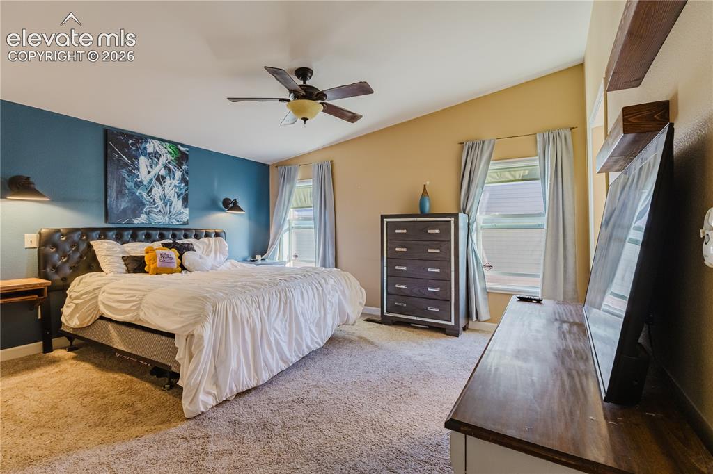 Image 17 of 30: Spacious bedroom featuring vaulted ceilings, a ceiling fan with integrated