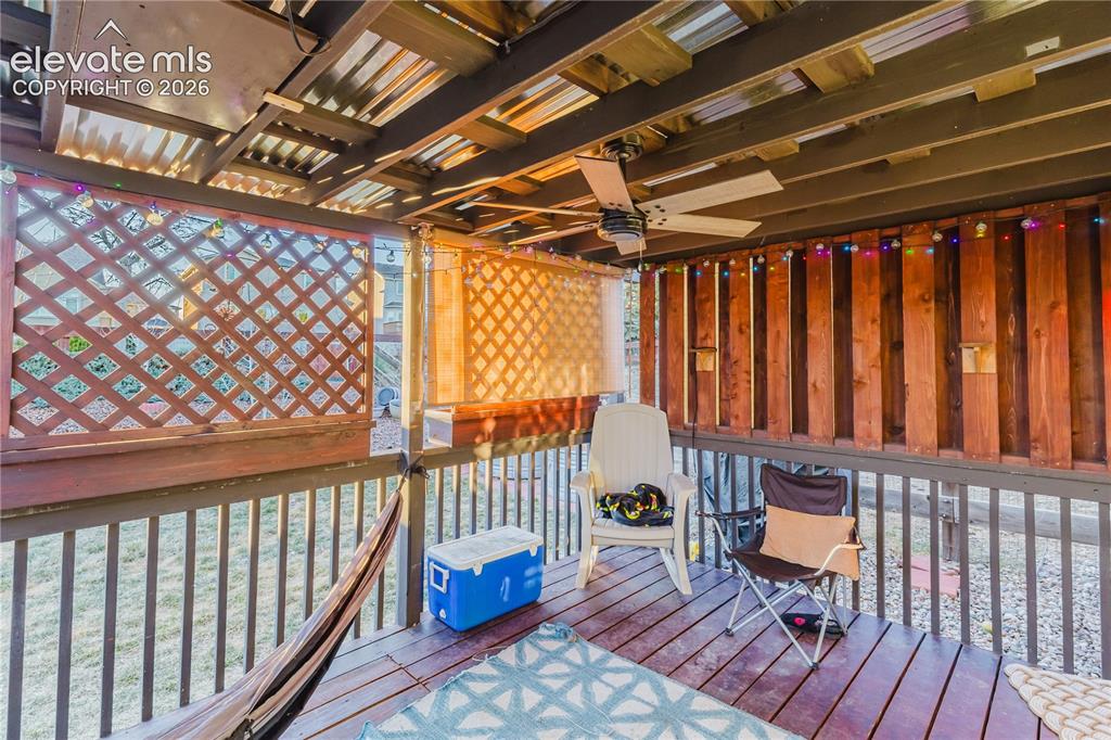 Image 27 of 30: Covered deck featuring wood-finish flooring, a corrugated metal roof, and a