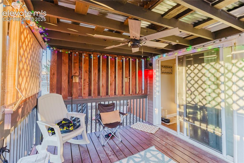 Image 28 of 30: Covered outdoor deck featuring wood-finish flooring, a ceiling fan, and a s