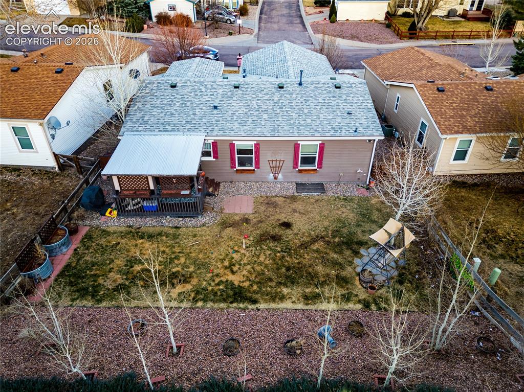 Image 4 of 30: Rear exterior featuring a covered deck, fenced yard, and a light gray shing