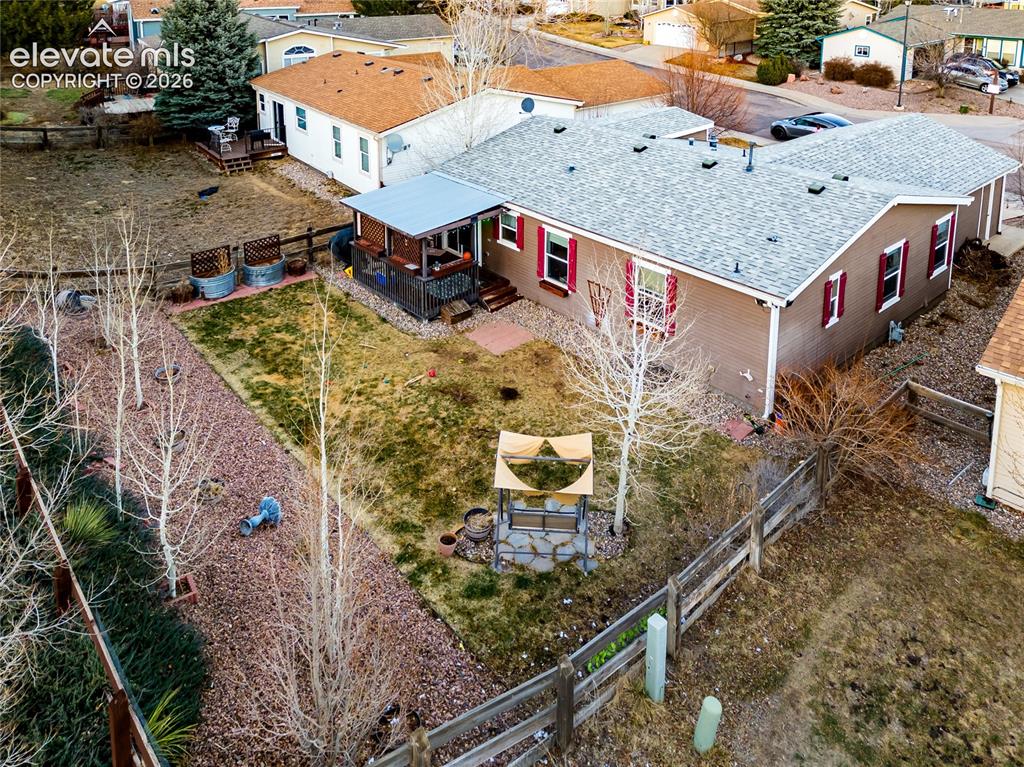Image 5 of 30: Spacious rear yard featuring a covered porch, wood fence perimeter, and mat