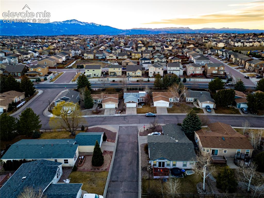 Image 6 of 30: Aerial view of a residential neighborhood with distant snow-capped mountain