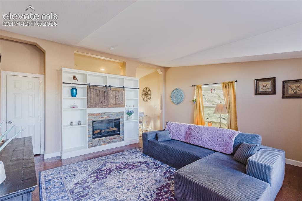 Image 7 of 30: Built-in entertainment center featuring a stone-faced fireplace with barn-s