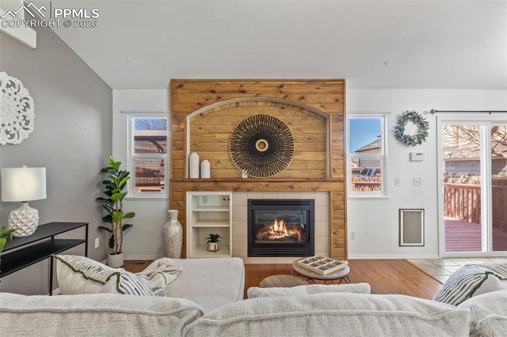 Image 2 of 50: Living area featuring wood finished floors and a fireplace
