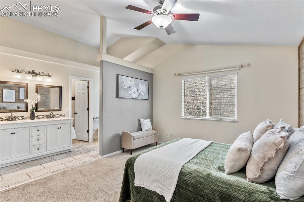 Image 20 of 50: Bedroom with lofted ceiling, a ceiling fan, light tile patterned floors, an