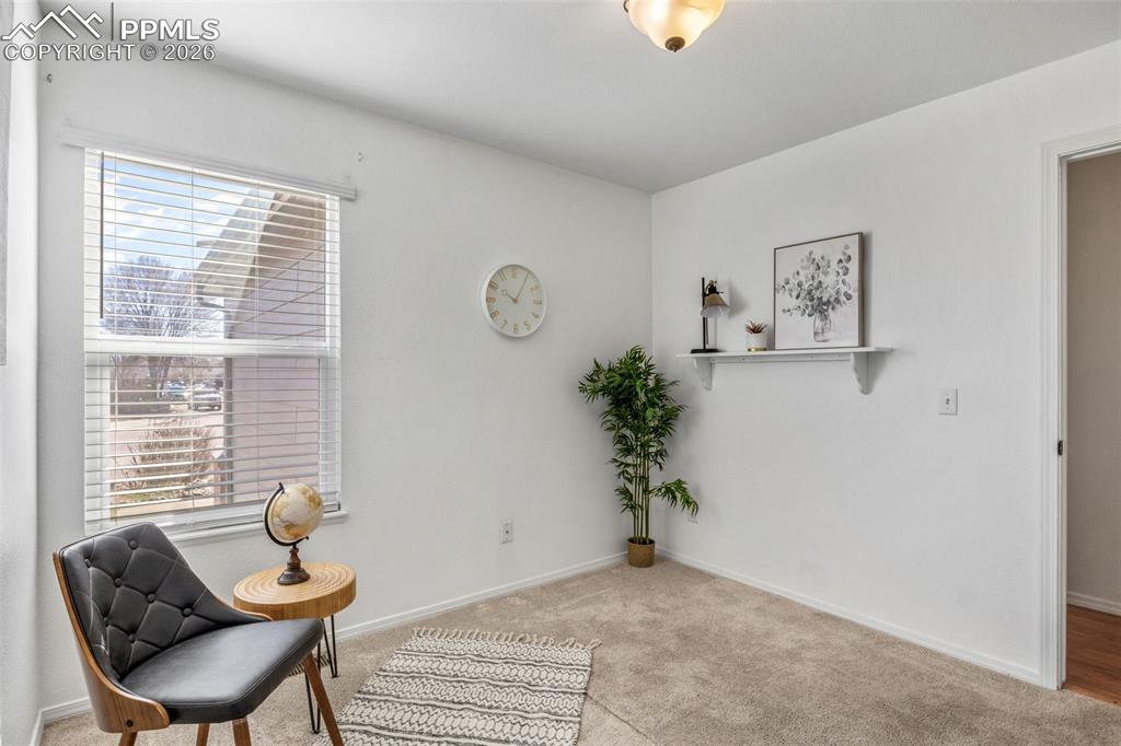 Image 27 of 50: Living area with light carpet and baseboards
