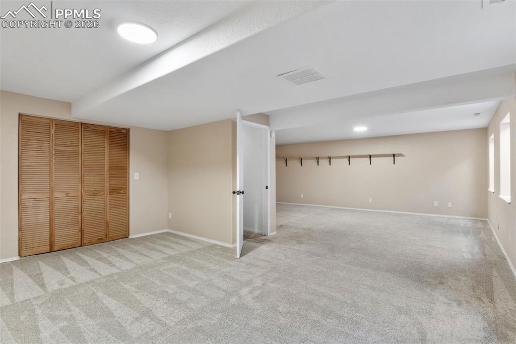 Image 29 of 50: Finished below grade area with light colored carpet and baseboards