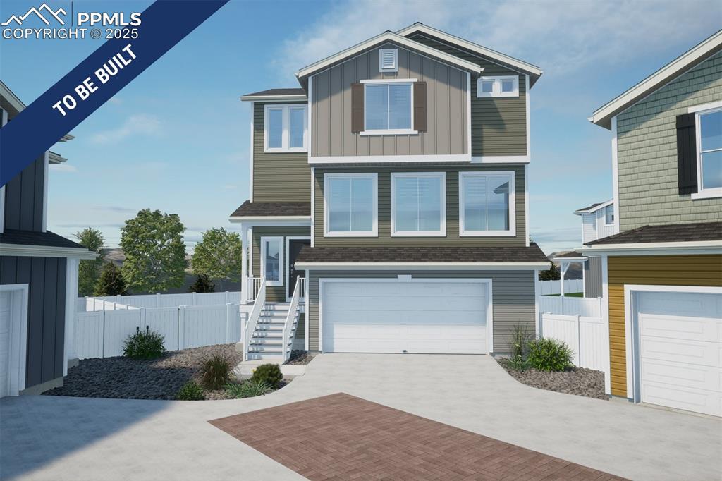 Caption: View of front of property featuring decorative driveway, an attached garage, board and batten siding